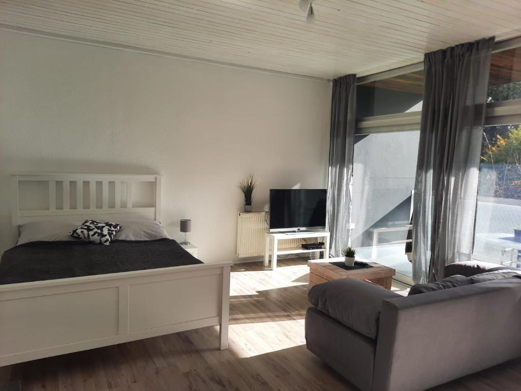 sypialnia z łóżkiem i kanapą w obiekcie Ferienwohnung K1 w mieście Hambühren