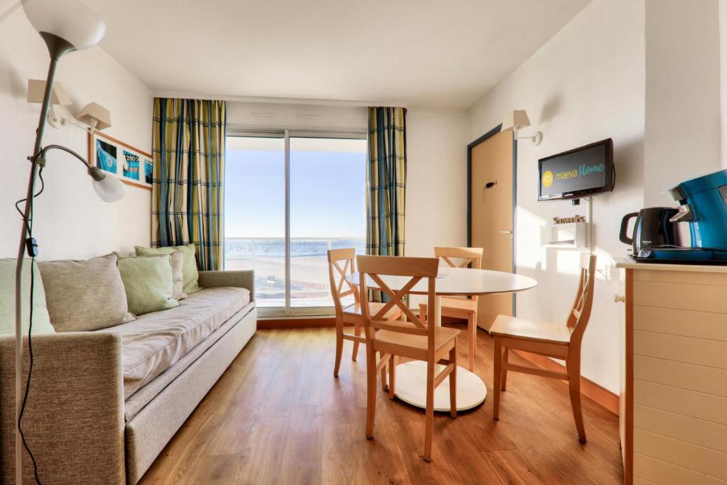 un salon avec un canapé et une table dans l'établissement Résidence Les Océanes - maeva Home - Appartement 2 pièces 6 personnes Confort - vue mer MAE-9582, à Pornichet