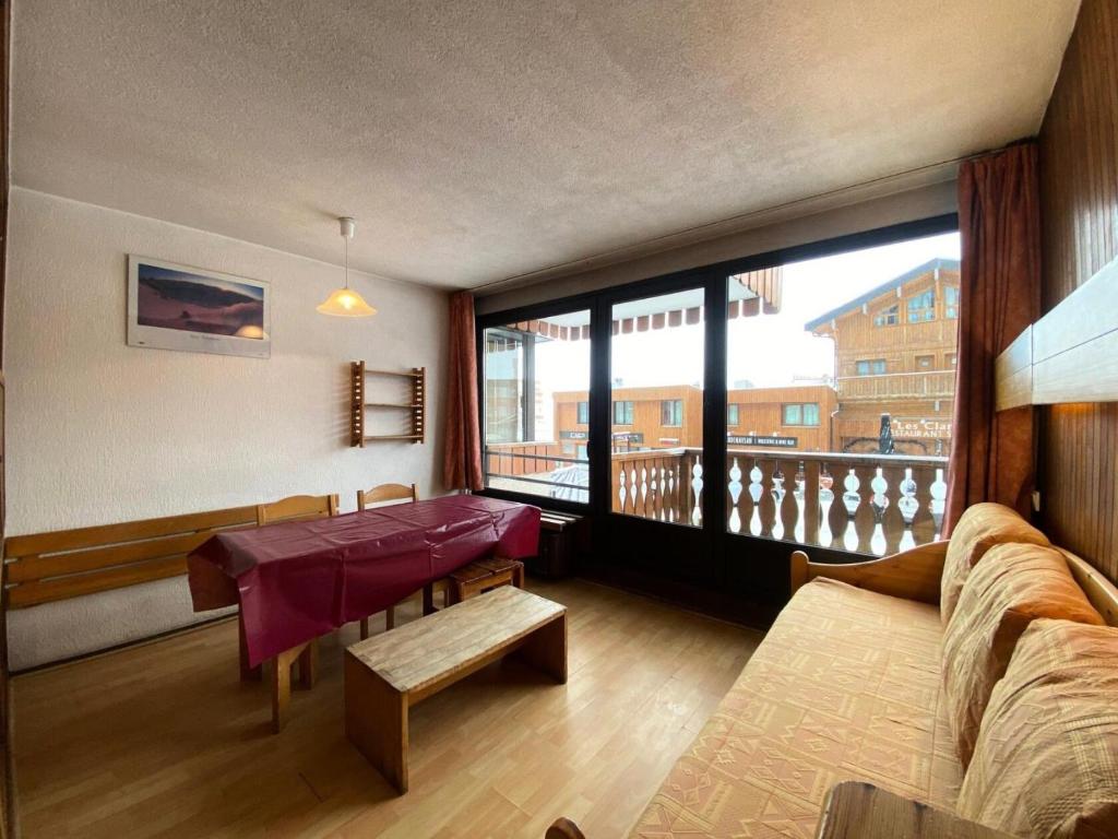 un salon avec une table et une grande fenêtre dans l'établissement Résidence Neves - VAL THORENS location: studio pour 4 personnes dans un quartier jeune et animé LES NEVES MAE-9062, à Val Thorens
