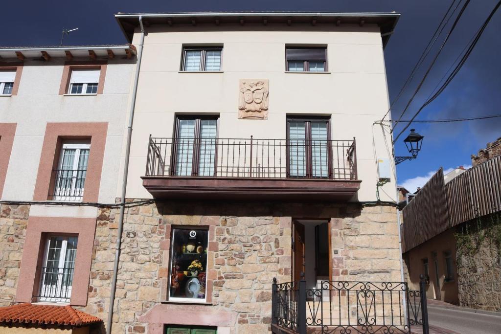 - un grand bâtiment blanc avec un balcon dans l'établissement Casa Lorea, à Barruelo de Santullán