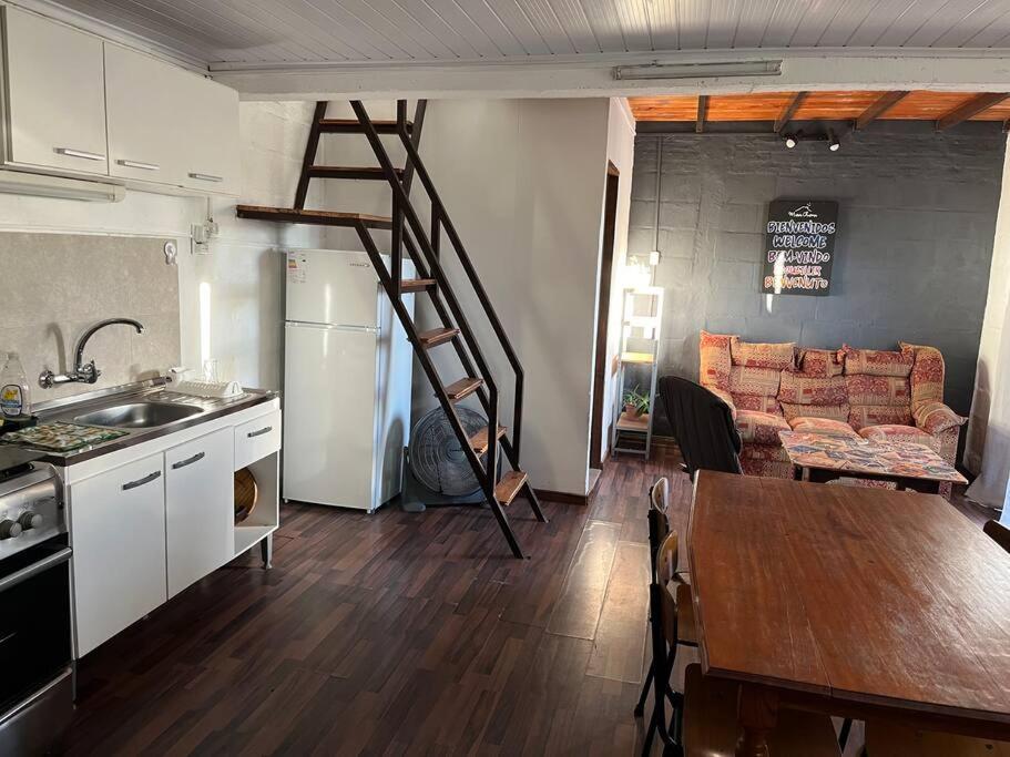 uma cozinha e uma sala de estar com uma escada num quarto em María Chusena alojamiento 2 em Fray Bentos