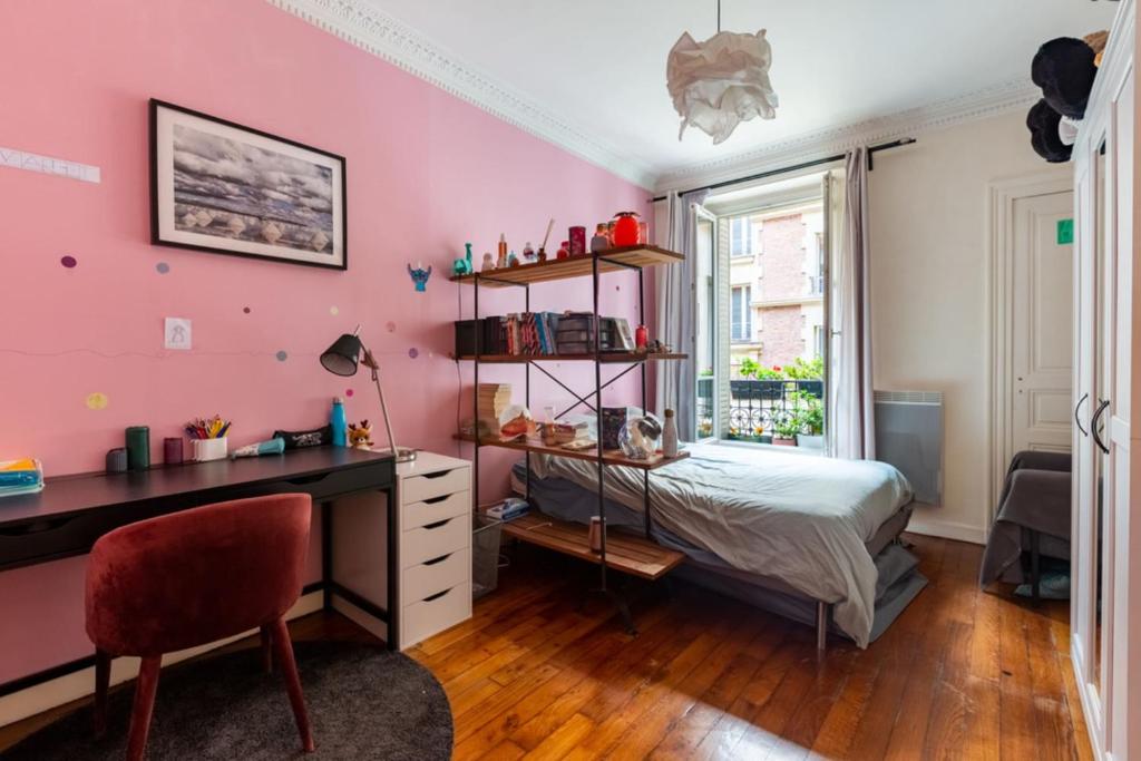 - une chambre aux murs roses avec un bureau et un lit dans l'établissement Spacious and pleasant nest 2 steps from Montmartre, à Paris