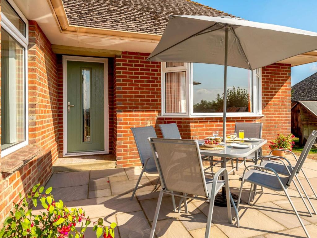 a patio with an umbrella and a table and chairs at 2 bed in Poole 85399 in Lytchett Matravers