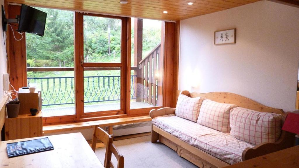 un salon avec un canapé et une grande fenêtre dans l'établissement Résidence Aiguille Grive Bat Iii - Appartement 2 pièces 6 personnes en duplex, skis aux pieds, dans le village de Charmettoger à Arc 1800 MAE-1696, à Arc 1800