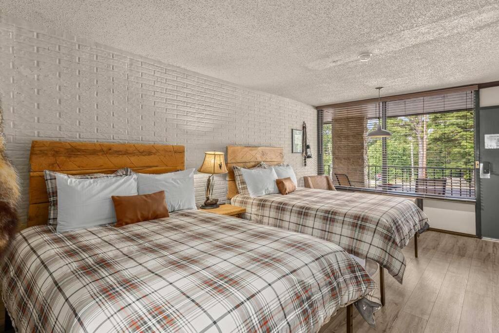 a bedroom with two beds and a window at Stonegate Lodge Saltwater Pool 2 Queen Beds Firepit Fast WiFi Room #307 in Eureka Springs