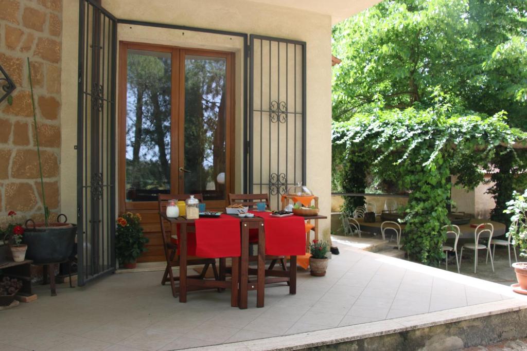patio ze stołem i czerwonymi krzesłami w obiekcie B&B La Roverella w mieście Piazza Armerina