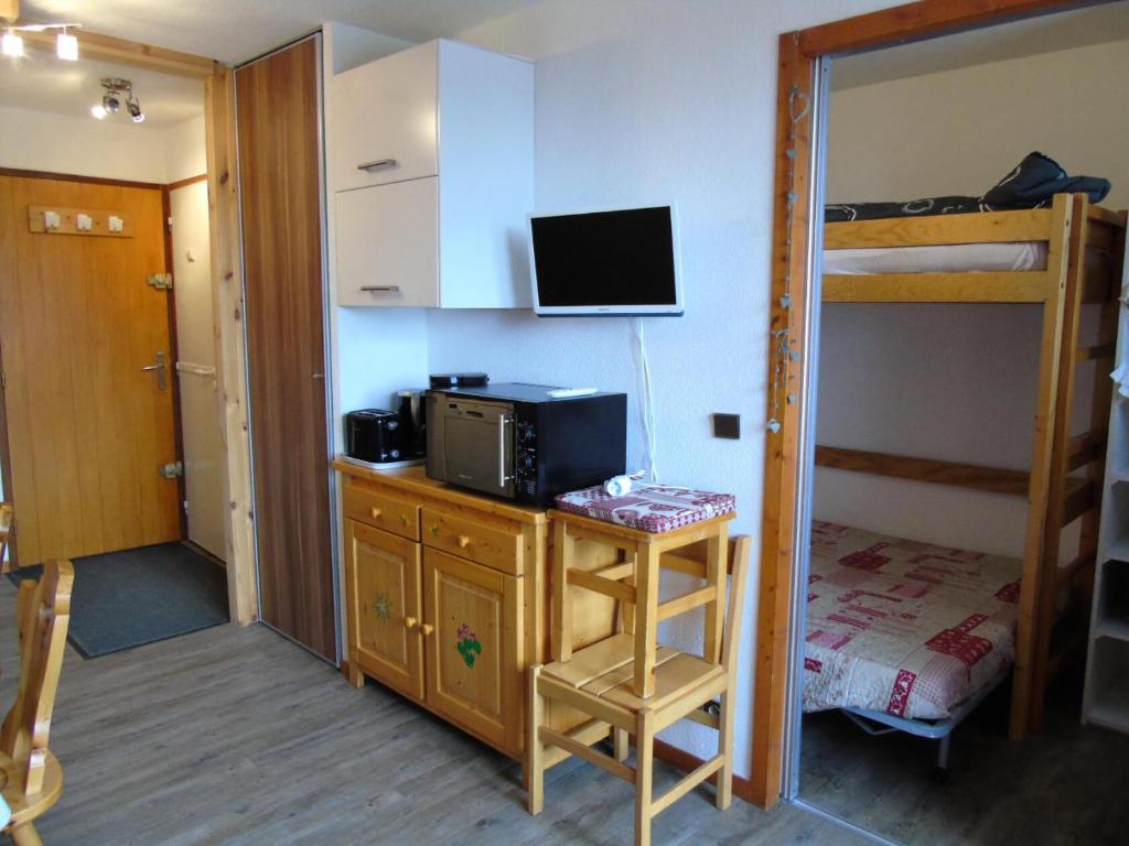 een kamer met een bureau, een magnetron en een stapelbed bij Résidence Melezets - Studio pour 4 Personnes 234 in Modane