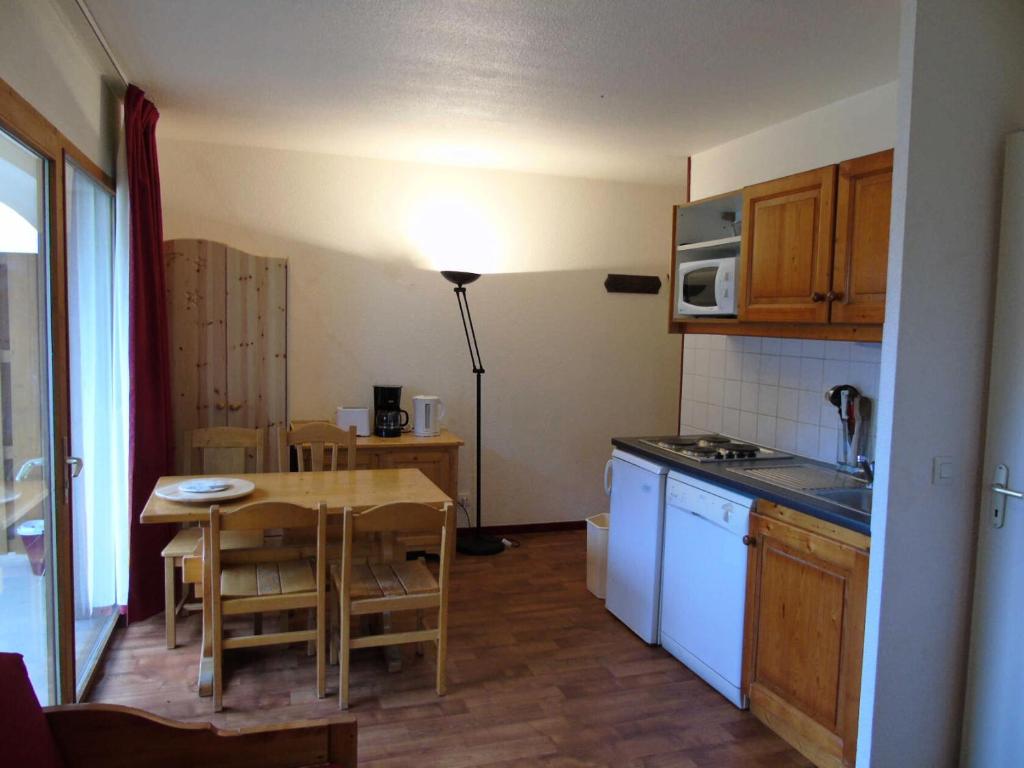 une cuisine avec une table et une petite cuisine avec une table et une table dans l'établissement Résidence Cheval Blanc - 2 Pièces pour 4 Personnes MAE-8564, à Modane