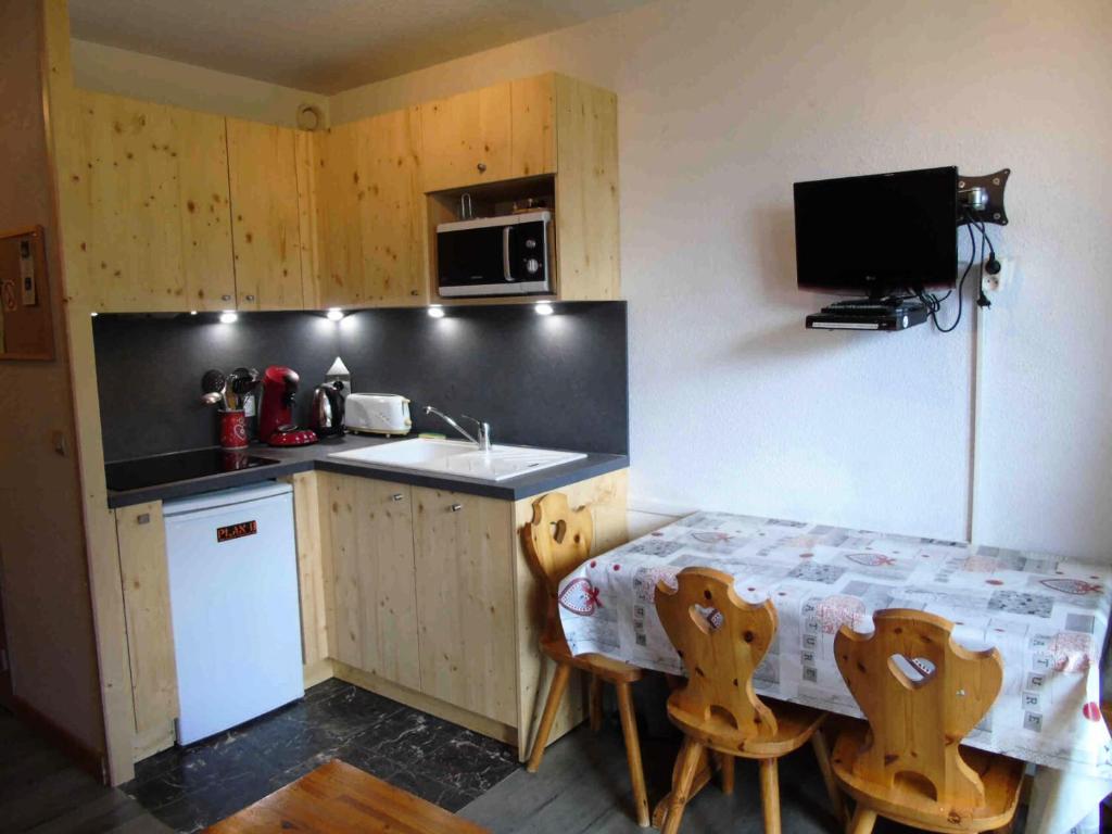 une cuisine avec une table et un évier et une table et des chaises dans l'établissement Résidence Vita Parc - Studio pour 4 Personnes MAE-8514, à Modane