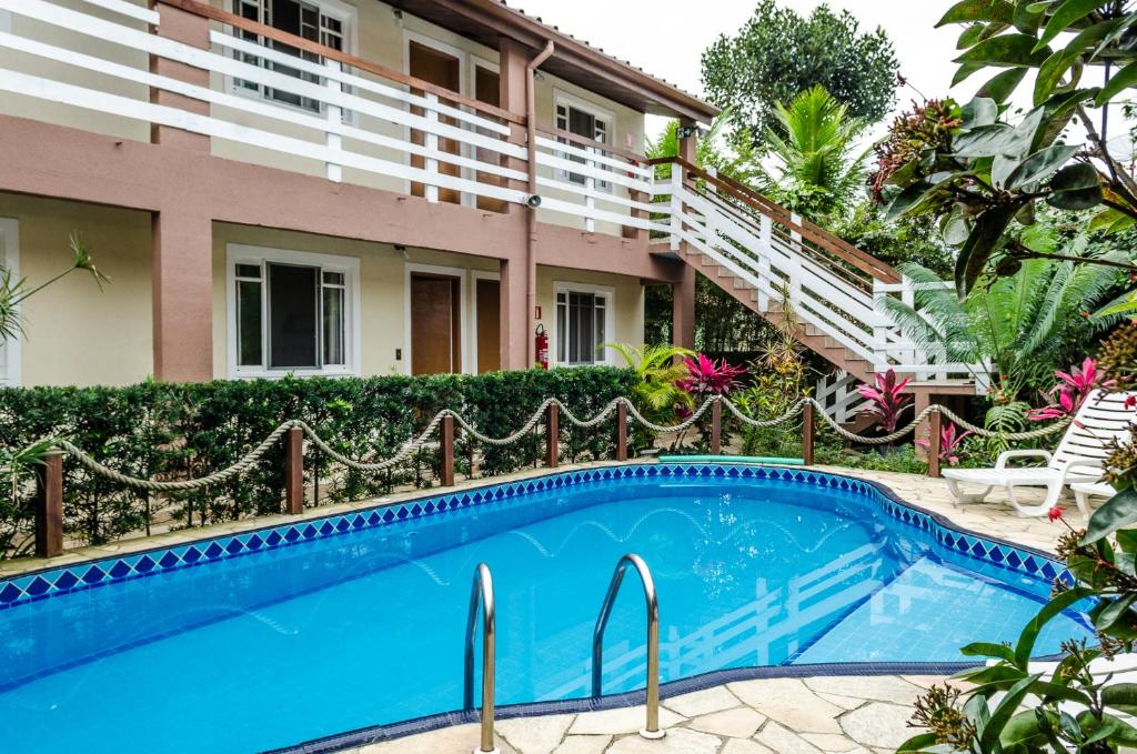 a swimming pool in front of a building at Pousada Vila da Praia in Bertioga