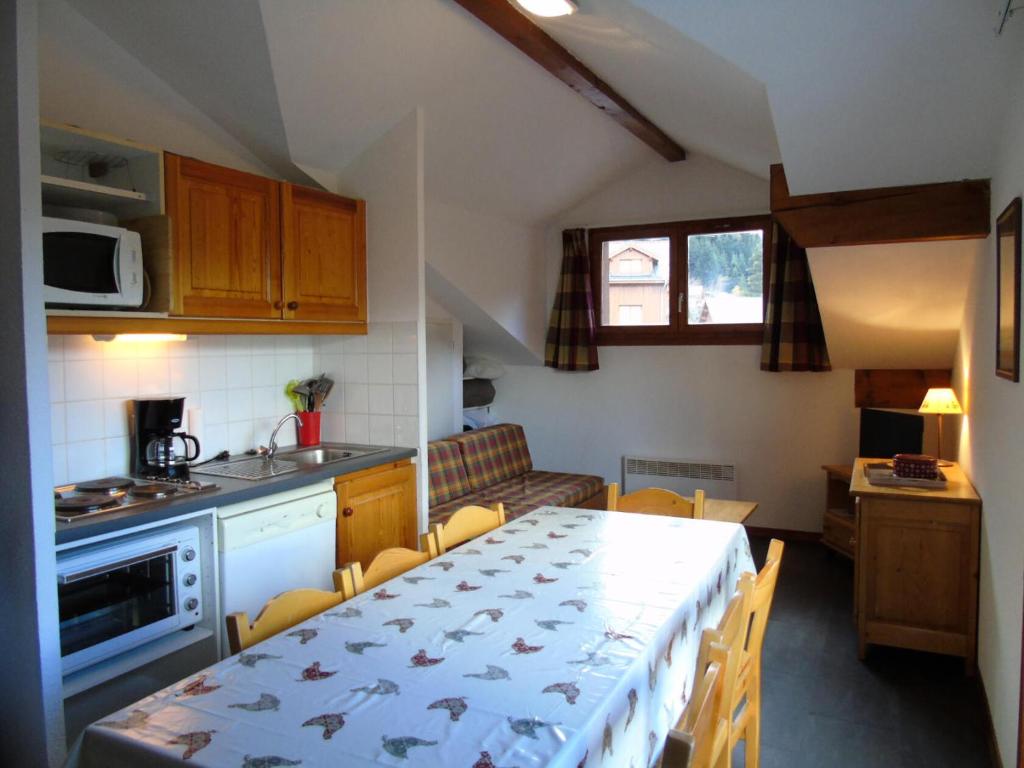 une cuisine et une salle à manger avec une table et des chaises dans l'établissement Chalet Arrondaz - 3 Pièces pour 8 Personnes MAE-8734, à Modane