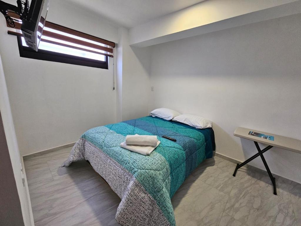 a bedroom with a bed with a green blanket at Habitación Privada 5-B Centro Expositor in Puebla