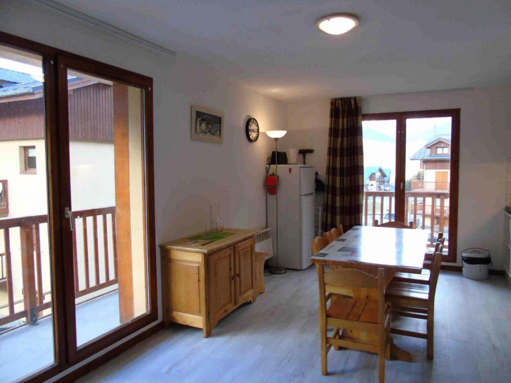 une cuisine et une salle à manger avec une table et un réfrigérateur dans l'établissement Chalet Arrondaz - 2 Pièces pour 6 Personnes MAE-8664, à Modane
