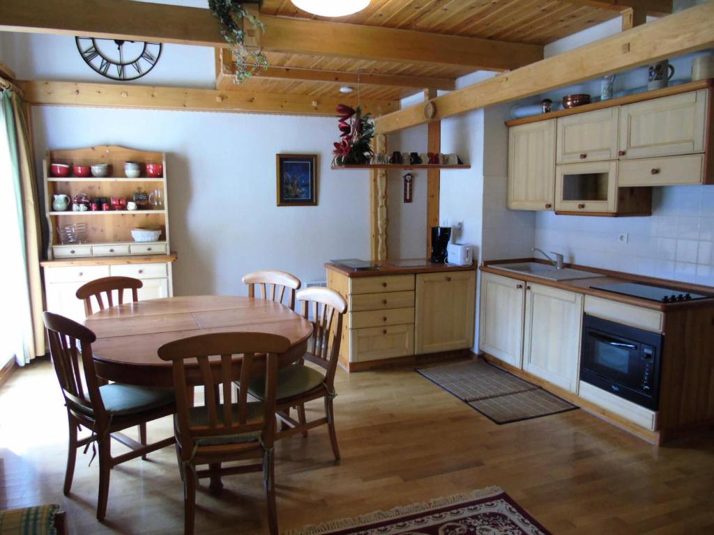 une cuisine avec une table et des chaises dans une pièce dans l'établissement Résidence Cheval Blanc - 4 Pièces pour 8 Personnes MAE-8774, à Modane