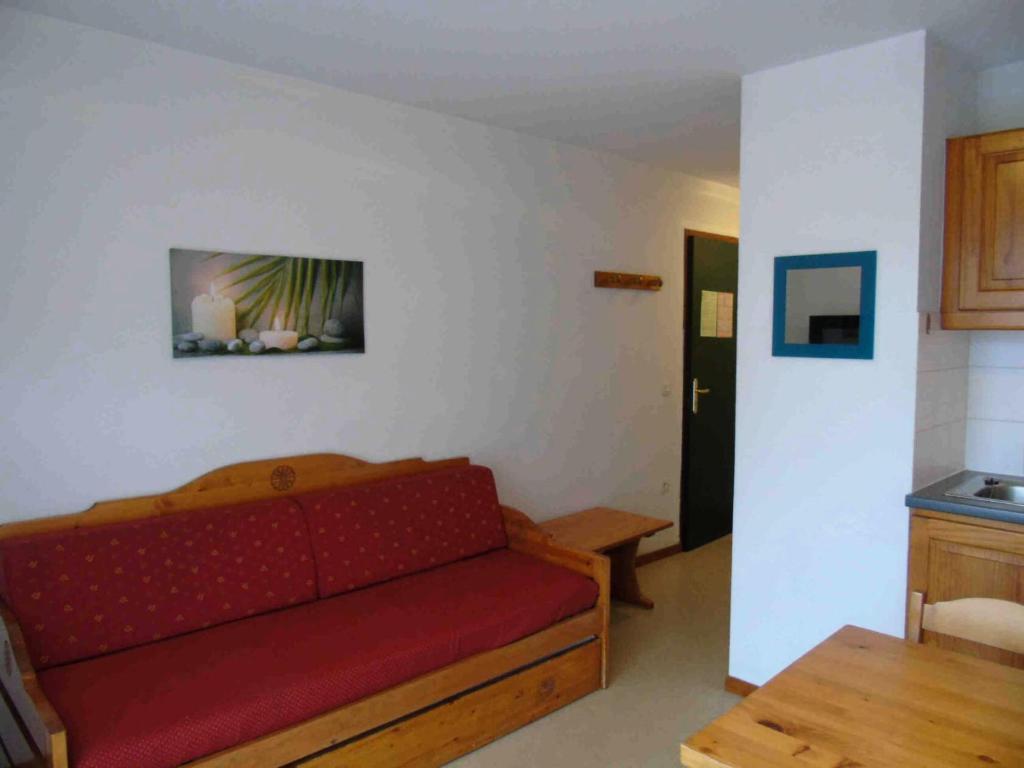 un salon avec un canapé rouge et une table dans l'établissement Chalet Arrondaz - 2 Pièces pour 4 Personnes MAE-8794, à Modane