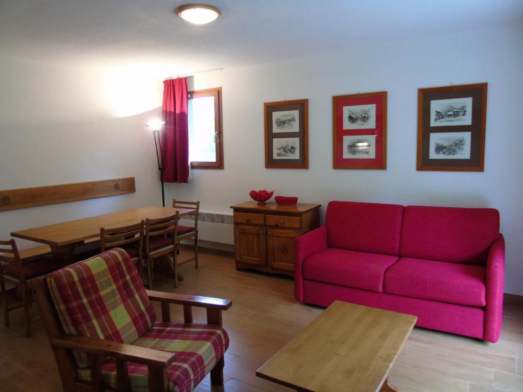 un salon avec un canapé rouge et une table dans l'établissement Résidence Cheval Blanc - 2 Pièces pour 6 Personnes MAE-8884, à Modane