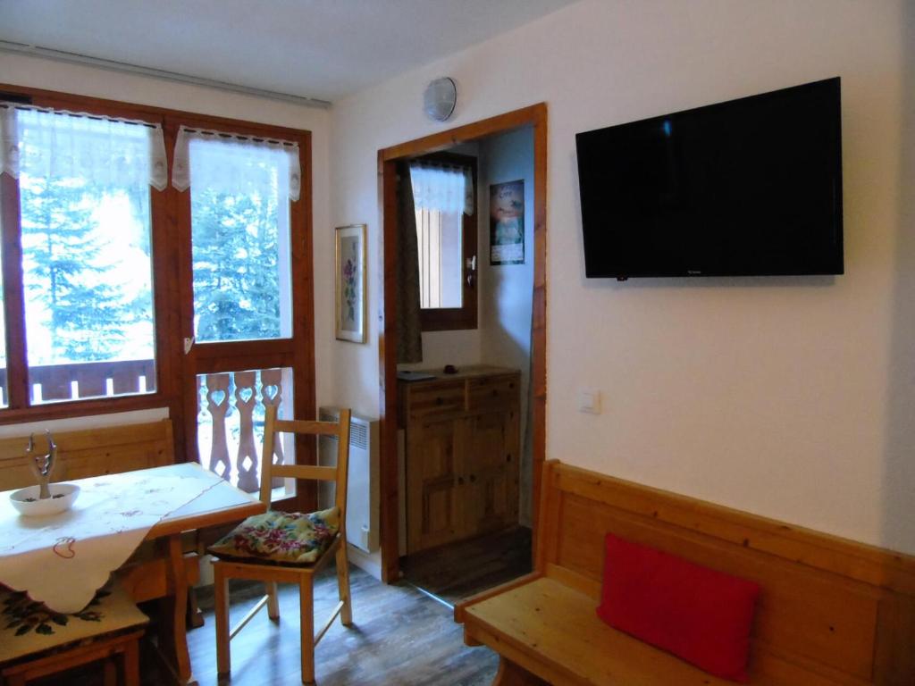 un salon avec une table et une télévision murale dans l'établissement Résidence Melezets - Studio pour 4 Personnes MAE-8974, à Modane
