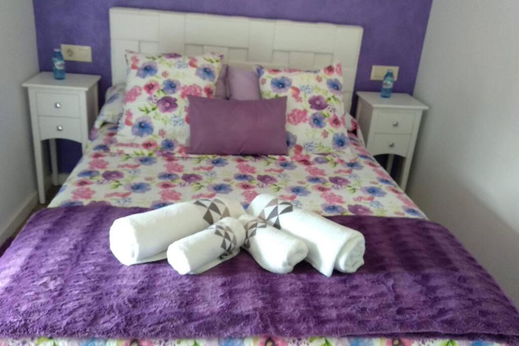 ein Bett mit zwei weißen Handtüchern auf einer lila Decke in der Unterkunft Casa Rústica Con Encanto. in Brandomil