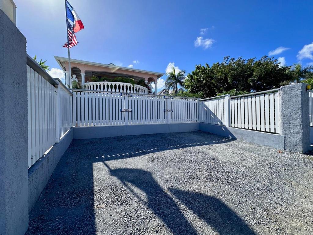 a white fence with an american flag on a house at Sun Caraibes in Orient Bay