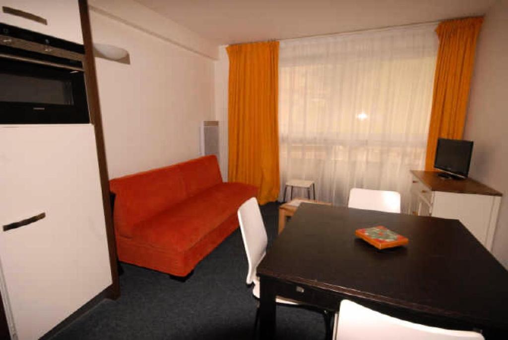 ein Wohnzimmer mit einem Tisch und einem Sofa in der Unterkunft Résidence MARMOTTES - Studio pour 4 Personnes 004 in Gourette