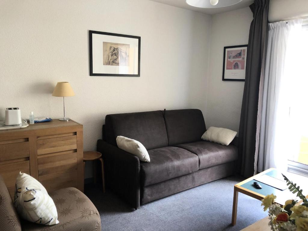 un salon avec un canapé et une table dans l'établissement Résidence MARMOTTES - Studio pour 4 Personnes MAE-8924, à Gourette