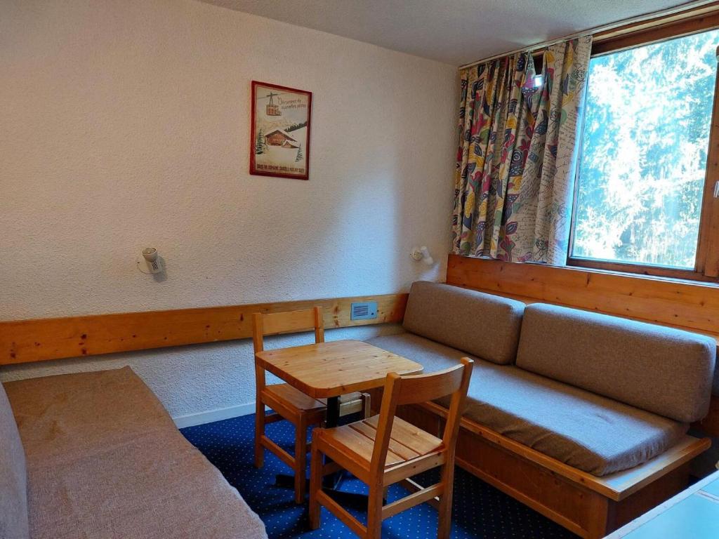 une chambre avec un canapé, une table et une fenêtre dans l'établissement Résidence Nova - Studio 2 personnes, proche des pistes et des commerces, au cœur de la station d’Arc 1800 dans le village des Villards MAE-1856, à Arc 1800