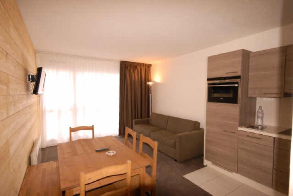 Apartamento pequeño con mesa y sofá en Résidence EURONEIGE - Studio pour 6 Personnes 974, en Gourette