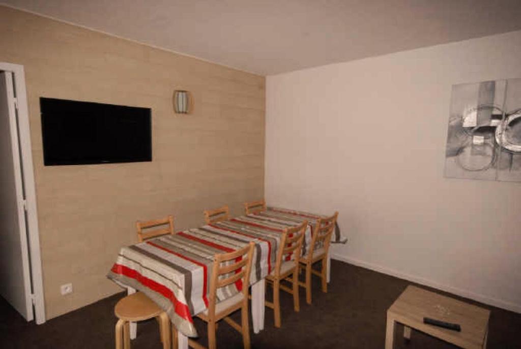 une salle à manger avec une table, des chaises et une télévision dans l'établissement Résidence ISARDS - 2 Pièces pour 8 Personnes 094, à Gourette
