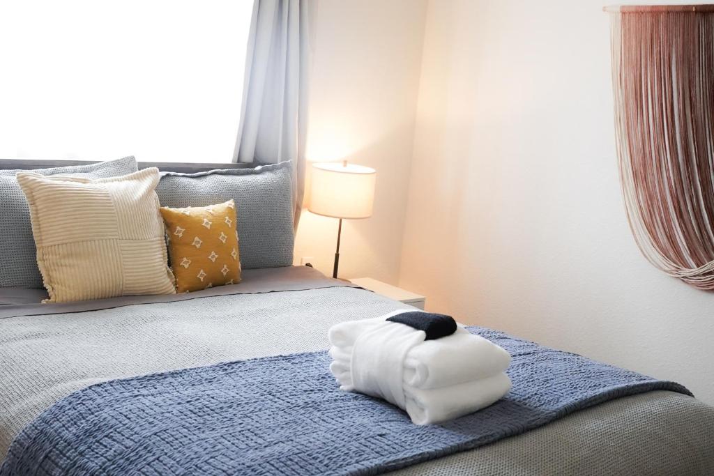 サウス・レイクタホにあるAdventure Lodgeの白いタオル付きのベッドが備わる客室です。