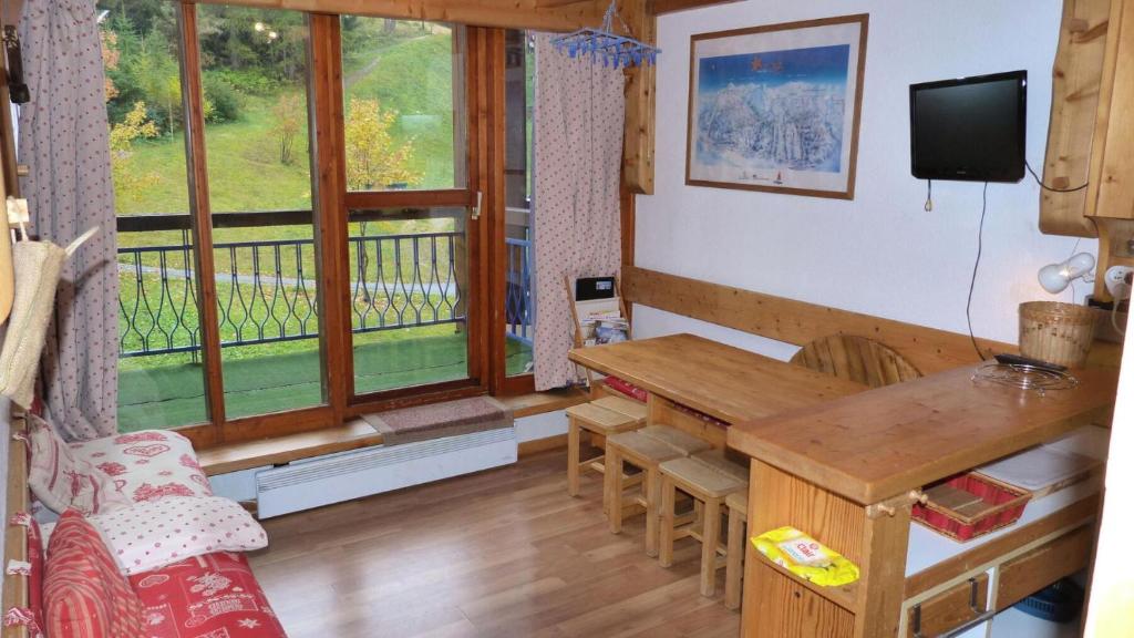 Il comprend un salon avec une table en bois et un balcon. dans l'établissement Résidence Aiguille Grive Bat Ii - Appartement 2 pièces en duplex pour 5 personnes proche des pistes dans le village de Charmettoger à Arc 1800 MAE-1907, à Arc 1800