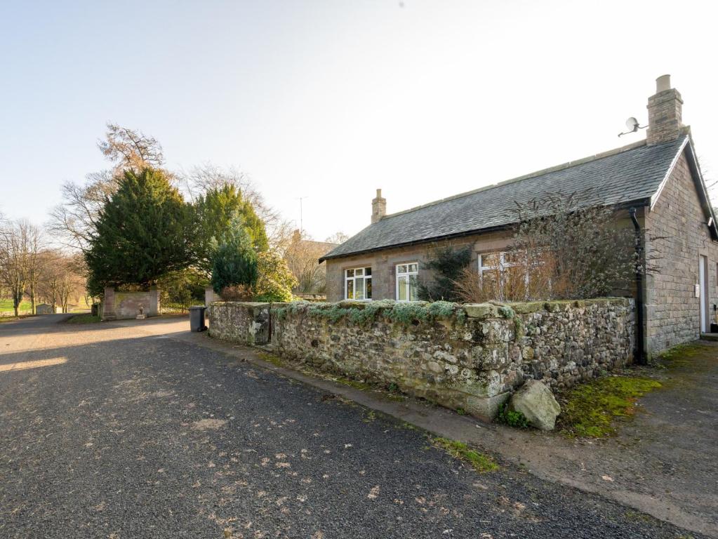 a stone house with a stone wall next to a street at 3 Bed in Kelso 76374 