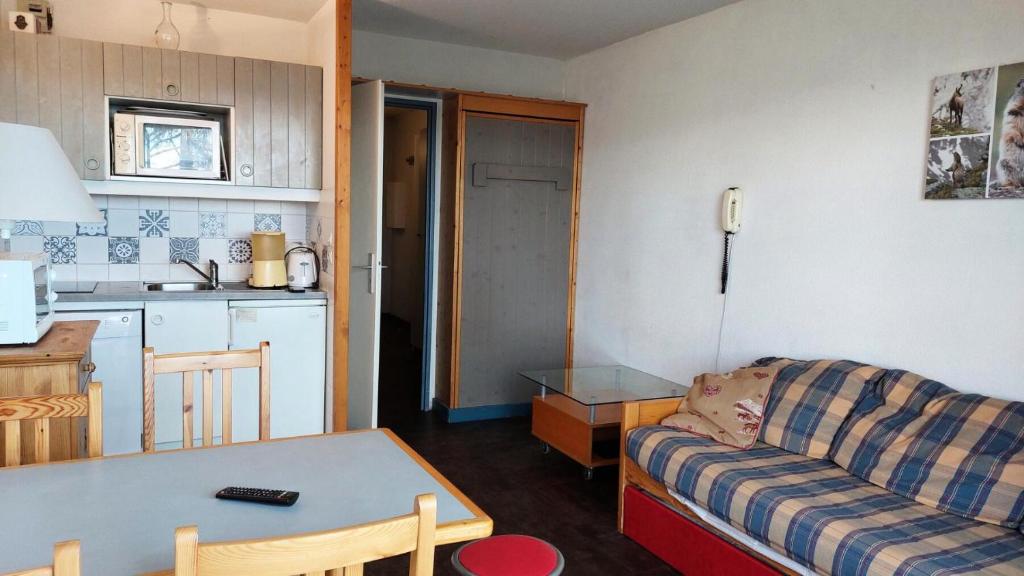 kuchnia i salon z kanapą i stołem w obiekcie Résidence Ruitor Arc 1800 - Appartement 2 pièces 5 personnes avec une belle vue sur la vallée, proche du télécabine dans le village de Charmettoger à Arc 18 MAE-1928 w mieście Arc 1800