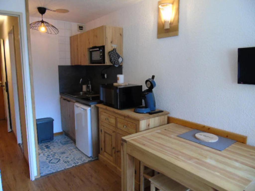 a kitchen with a table and a counter with a microwave at Résidence Thabor - Studio pour 3 Personnes 704 in Modane