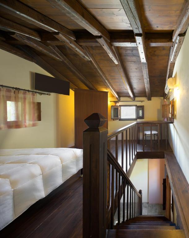 a bedroom with a large bed and a staircase at Porto Kale Guesthouse in Porto Kagio