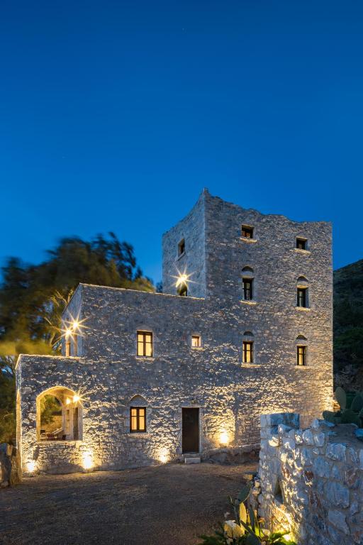 a large stone building with lights on it at night at Porto Kale Guesthouse in Porto Kagio