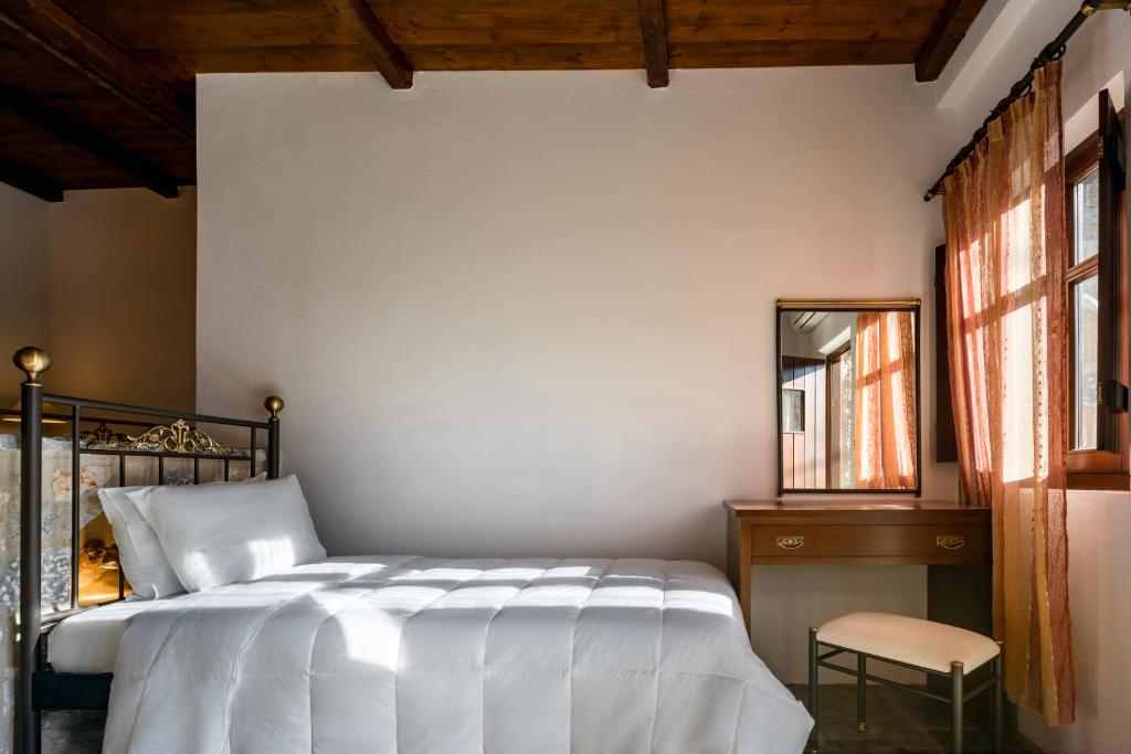 a bedroom with a bed and a mirror and a chair at Porto Kale Guesthouse in Porto Kagio