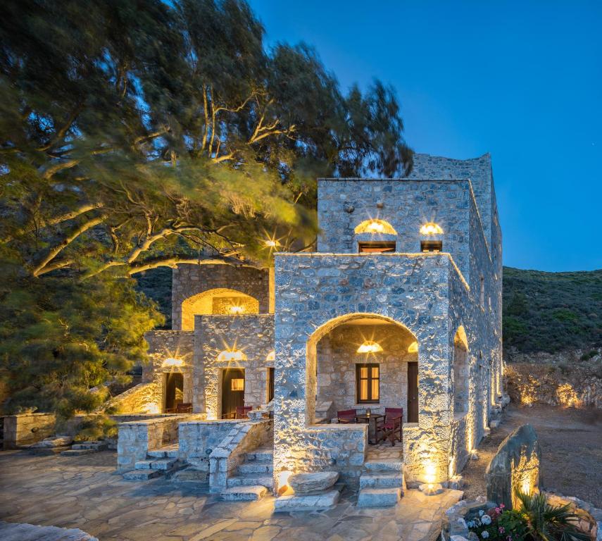 a stone house with lights on it at night at Porto Kale Guesthouse in Porto Kagio