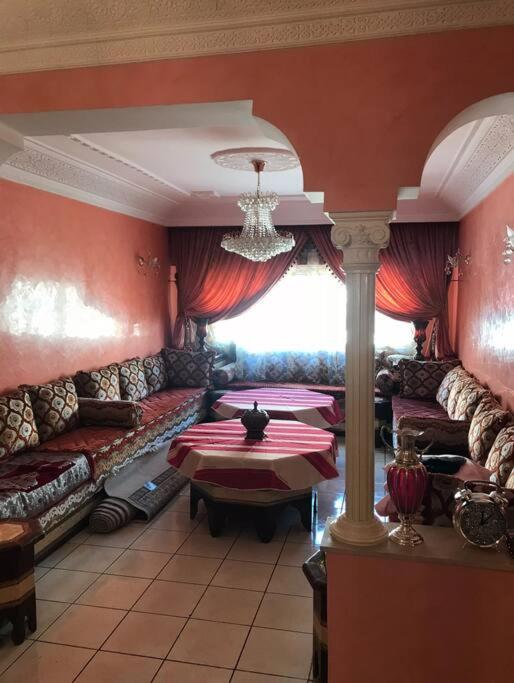 カサブランカにあるBel appartement à Casablanca 2 chambresのリビングルーム(ソファ、テーブル付)、窓が備わります。