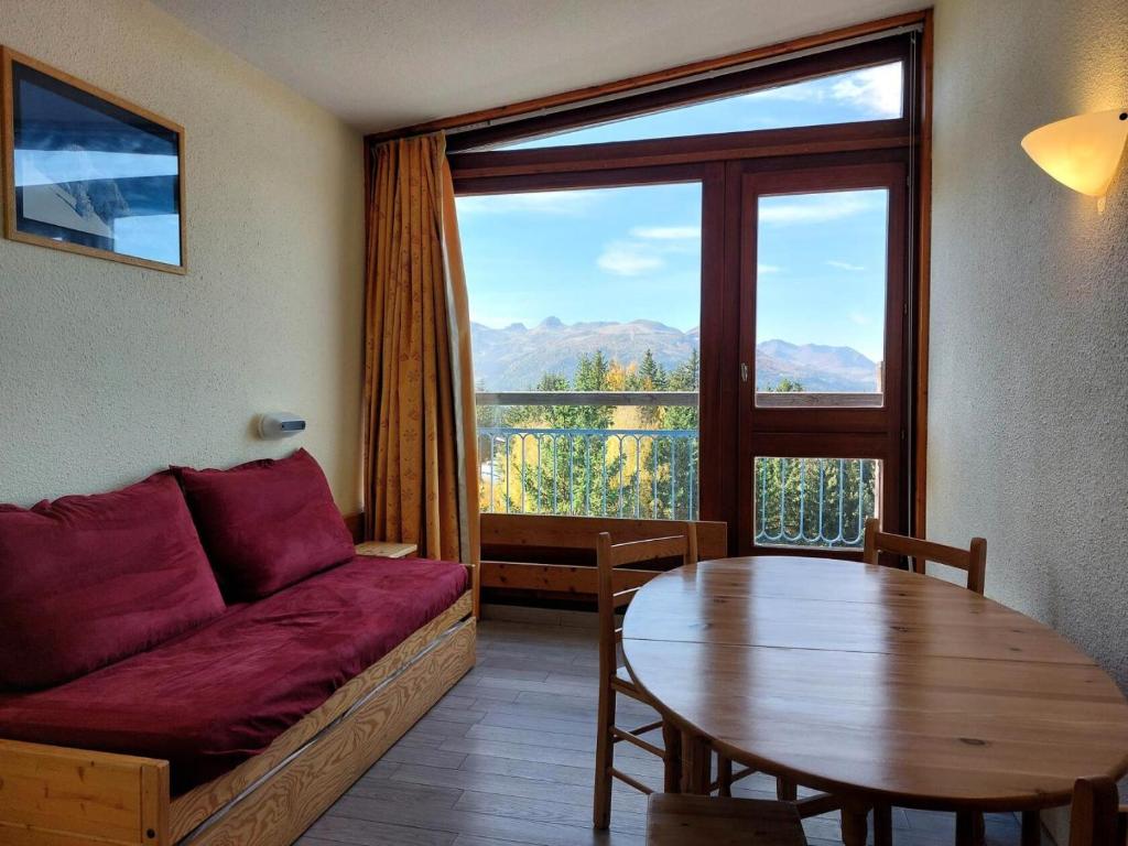 een woonkamer met een bank en een tafel bij Résidence Belles Challes - Studio 4 personnes à Arc 1800 skis aux pieds et proche des commerces dans le village du Charvet MAE-1962 in Arc 1800