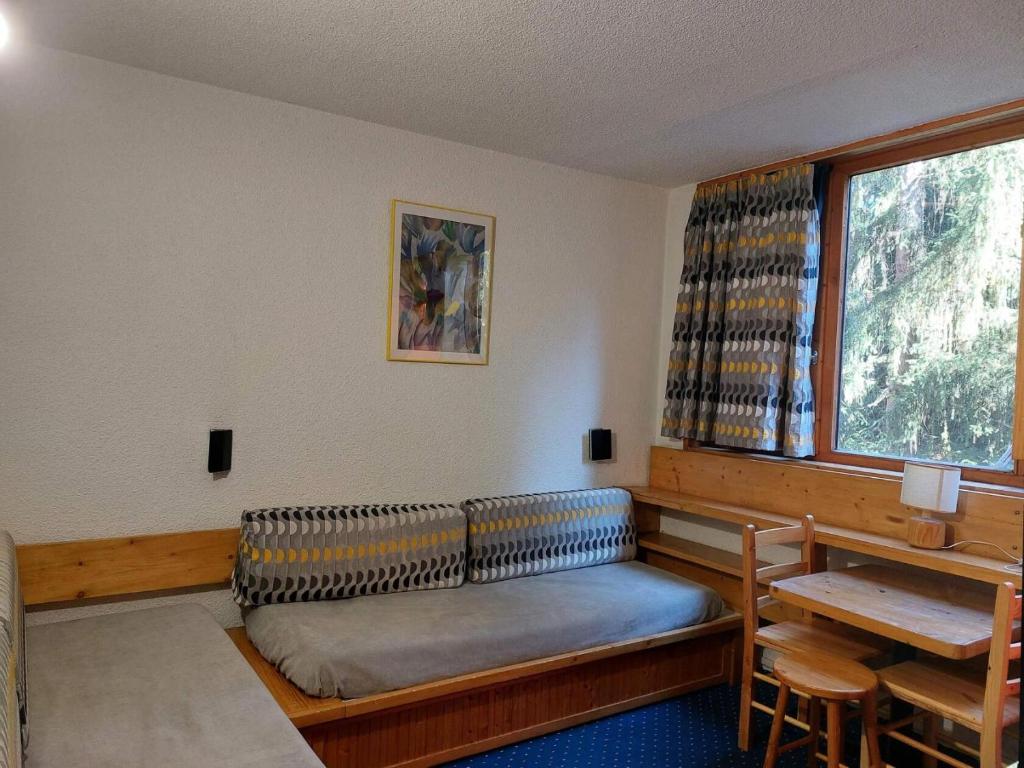 une chambre avec un canapé, une table et une fenêtre dans l'établissement Résidence Nova - Studio 2 personnes, proche des pistes et des commerces, au cœur de la station d’Arc 1800 dans le village des Villards MAE-1988, à Arc 1800