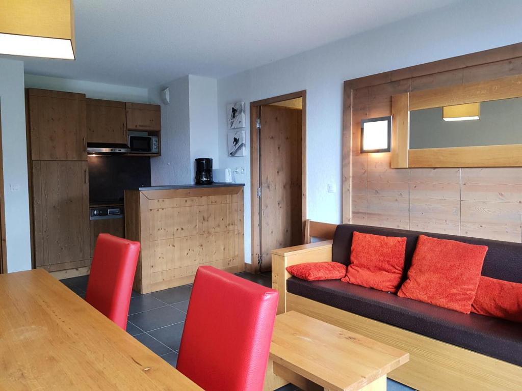 een woonkamer met een bank en een tafel met rode kussens bij Résidence Roc Belleface C - 3 Pièces pour 8 Personnes 98 in Arc 1600