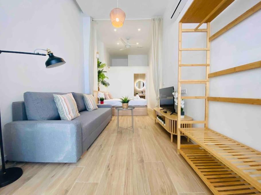 a living room with a blue couch and a ladder at Nice & Cozy Flat Close The Beach in Valencia