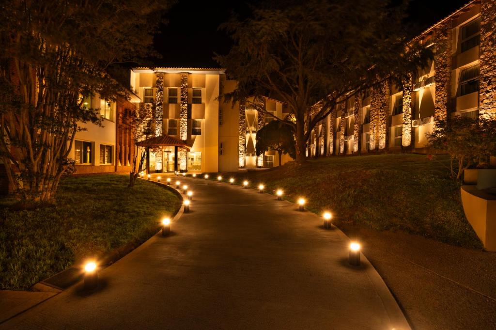 un marciapiede con luci di fronte a un edificio di notte di Hotel Intersur La Cumbre a La Cumbre