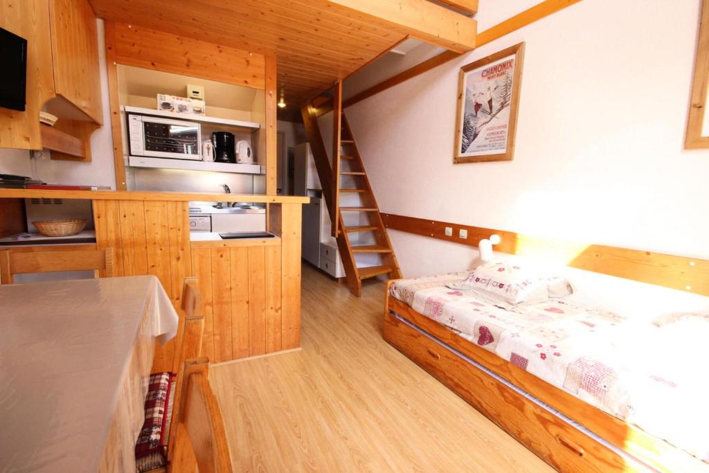 een kleine kamer met een bed en een trap bij Résidence Arc En Ciel - 2 Pièces pour 5 Personnes 63 in Peisey-Nancroix