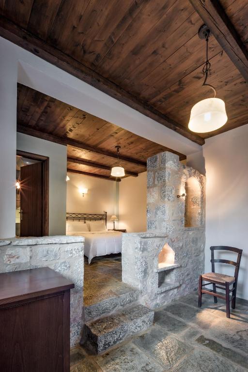 a bedroom with a bed and a stone fireplace at Porto Kale Guesthouse in Porto Kagio