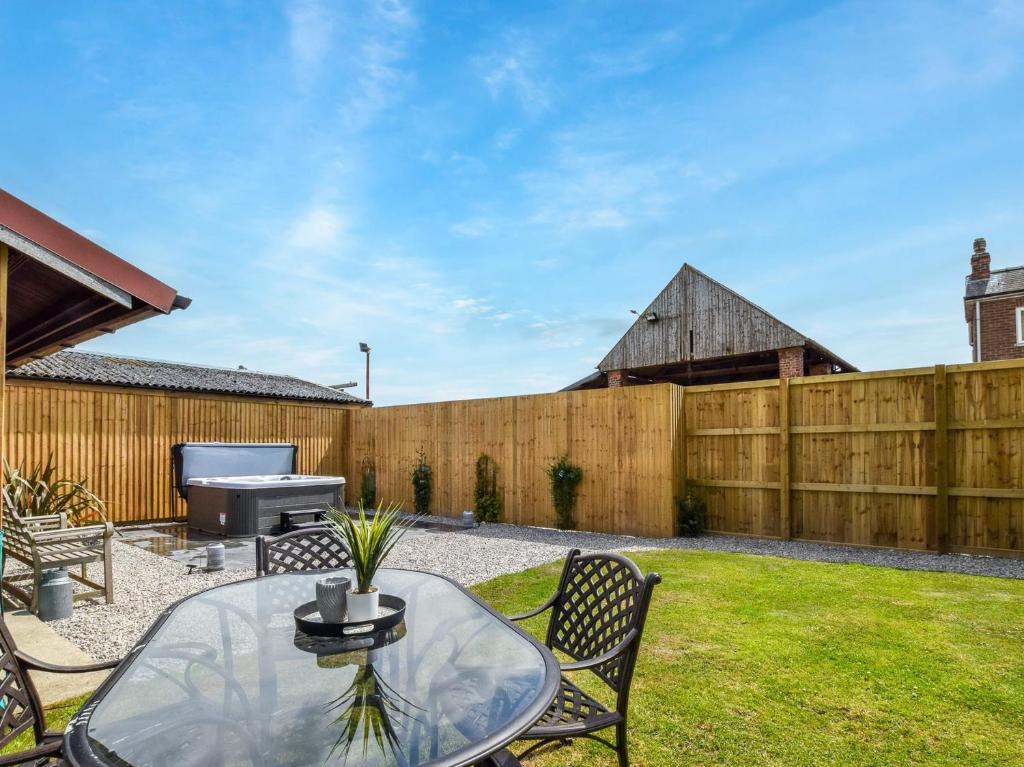 a backyard with a table and a grill and a fence at 3 Bed in Tollerton 87290 in Tollerton