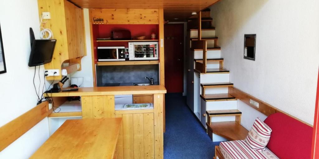 Kleines Zimmer mit einem Schreibtisch und einer Treppe in der Unterkunft Résidence Aiguille Grive Bat Ii - 2 Pièces pour 5 Personnes 75 in Arc 1800