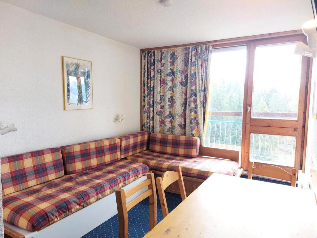 un salon avec un canapé et une fenêtre dans l'établissement Résidence Belles Challes - Studio 4 personnes à Arc 1800 skis aux pieds et proche des commerces dans le village du Charvet MAE-2128, à Arc 1800