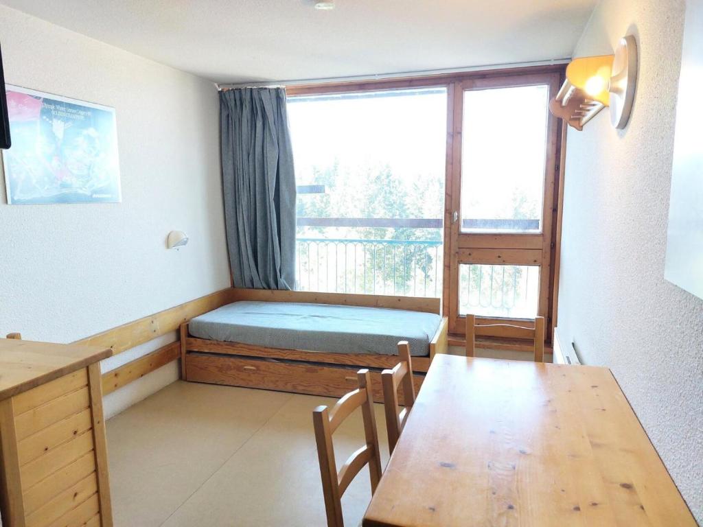 une chambre avec un lit, une table et une fenêtre dans l'établissement Résidence Belles Challes - Studio 4 personnes à Arc 1800 skis aux pieds et proche des commerces dans le village du Charvet MAE-2135, à Arc 1800
