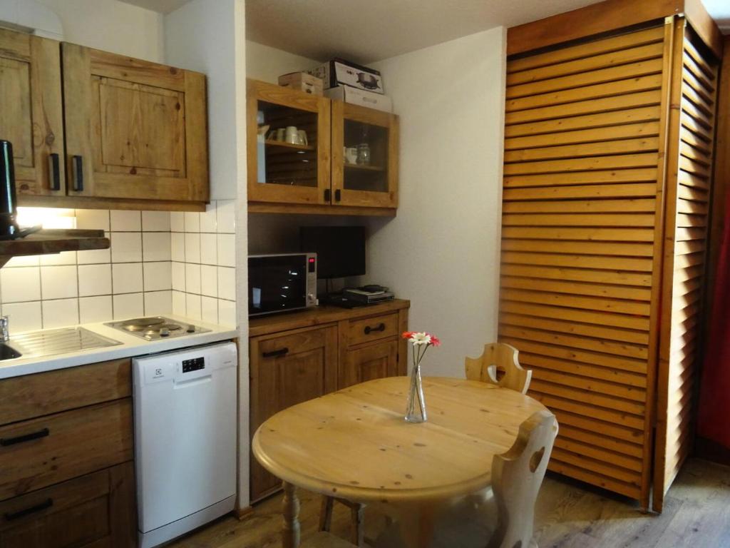 una cocina con una mesa de madera con un jarrón. en Résidence Fond Blanc - Studio pour 3 personnes à Arc 2000 proche des commerces et des pistes MAE-2149, en Arc 2000